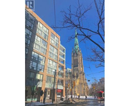 A tall building with a green spire stands behind a modern building with a red sign that says "Castro".