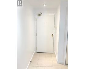 A white door in a room with a light switch on the wall.