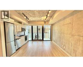 A kitchen with a refrigerator and wooden floors.