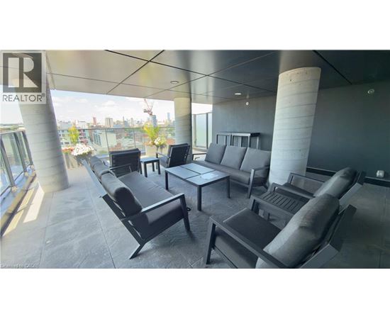 A modern living room with black furniture and a view of the city.
