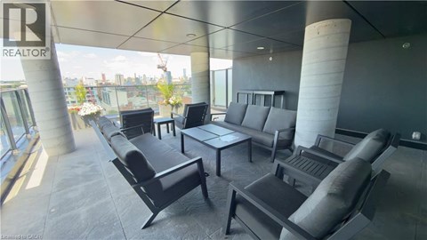 A modern living room with black furniture and a view of the city.