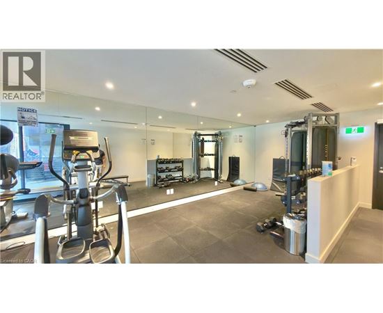 A gym with a variety of equipment including treadmills, weights, and exercise machines.