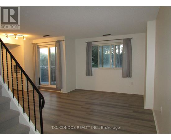 A room with a staircase and a window with a grey curtain.