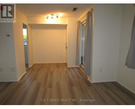 A room with wood flooring and white walls.