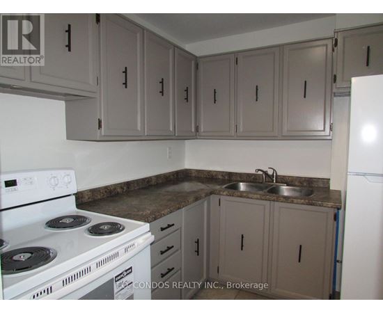 A kitchen with a white stove and cabinets.