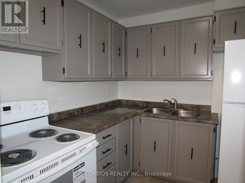 A kitchen with a white stove and cabinets.