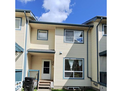 A beige house with a blue sky in the background.
