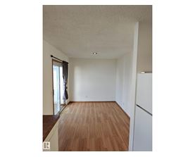 A room with wooden flooring and white walls.
