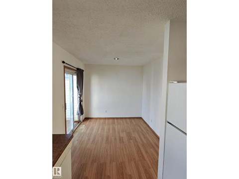 A room with wooden flooring and white walls.