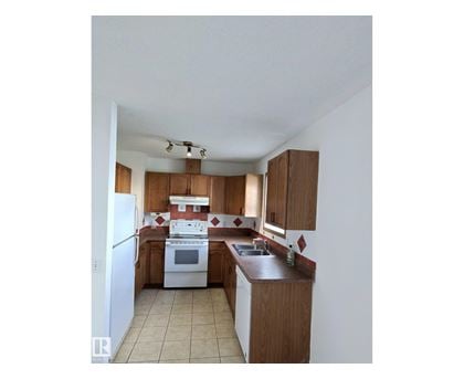 A kitchen with white appliances and wooden cabinets.