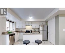 A kitchen with white cabinets and a stainless steel dishwasher.