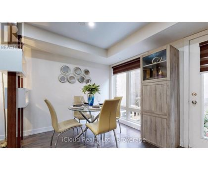 A dining room with a table set for two and a view of the backyard.