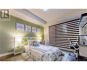 A bedroom with a bed, desk, and window with blinds.