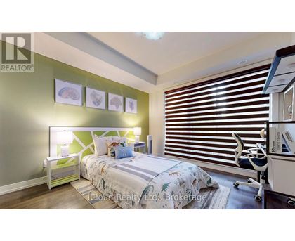 A bedroom with a bed, desk, and window with blinds.