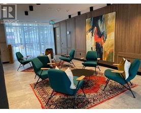 A conference room with green chairs and a large painting on the wall.