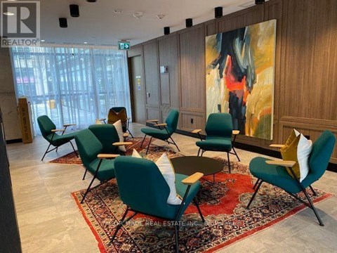 A conference room with green chairs and a large painting on the wall.
