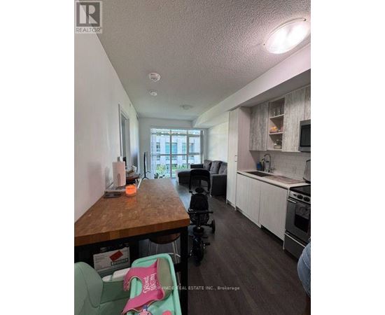 A kitchen with a wooden counter and a baby stroller.