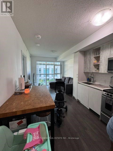 A kitchen with a wooden counter and a baby stroller.