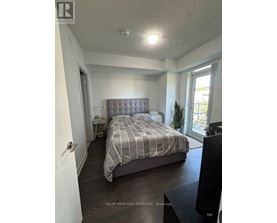 A bedroom with a bed, nightstand, and window.