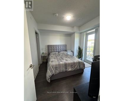 A bedroom with a bed, nightstand, and window.