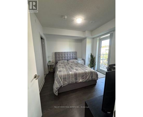 A bedroom with a bed, nightstand, and window.