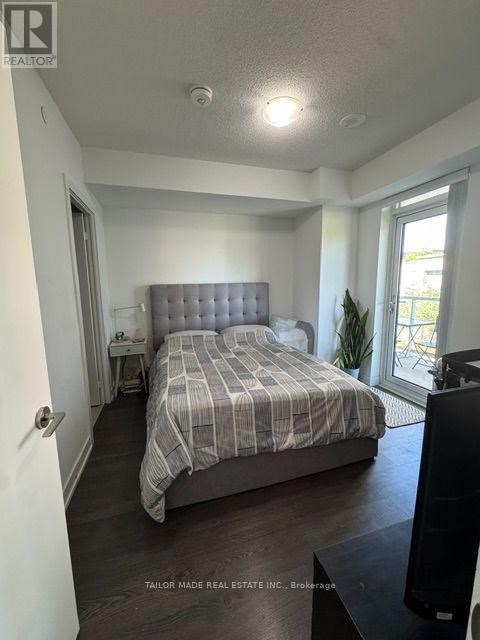 A bedroom with a bed, nightstand, and window.