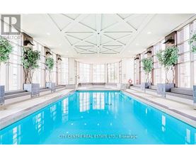 A large indoor swimming pool with a glass ceiling and a white floor.