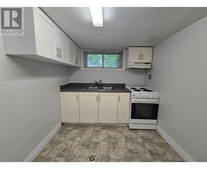 A kitchen with white cabinets and a black countertop.