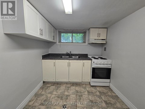 A kitchen with white cabinets and a black countertop.