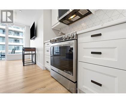 A modern kitchen with a stainless steel oven and white cabinets.