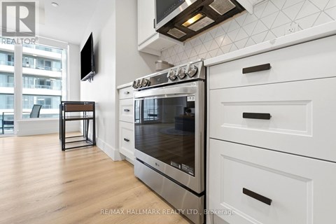 A modern kitchen with a stainless steel oven and white cabinets.