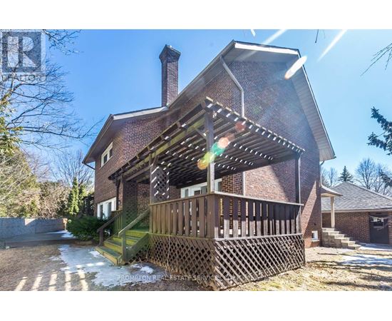 A house with a red brick exterior and a wooden deck.