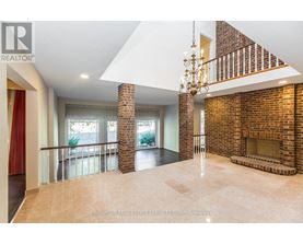 A large open space with a chandelier and a brick fireplace.