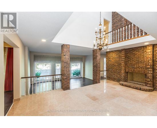 A large open space with a chandelier and a brick fireplace.