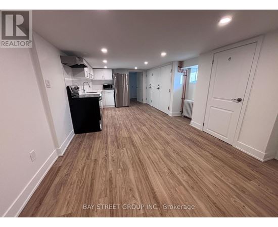 A spacious room with wooden flooring and white walls.