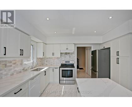 A modern kitchen with white cabinets and a marble countertop.