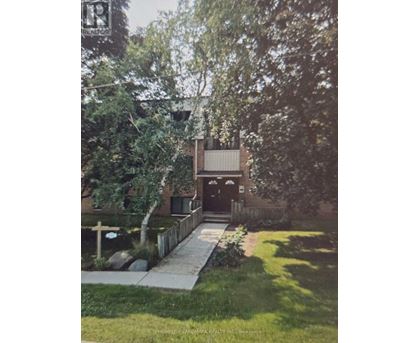 A house with a white fence and a tree in front of it.