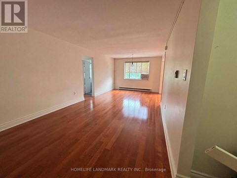 A room with wooden floors and a window is for sale.