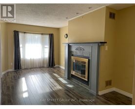 A living room with a fireplace and a window with curtains.