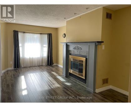 A living room with a fireplace and a window with curtains.