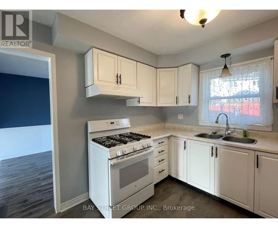 A kitchen with white cabinets and a stove top oven.