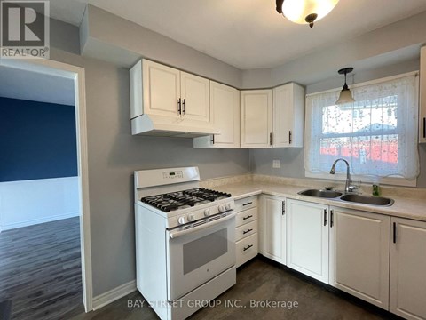 A kitchen with white cabinets and a stove top oven.