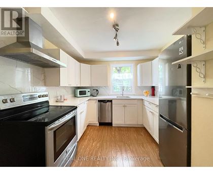 A kitchen with white cabinets and black appliances.