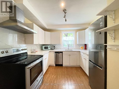 A kitchen with white cabinets and black appliances.