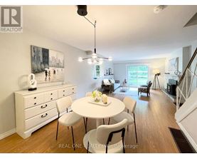 A dining room with a white table and chairs.