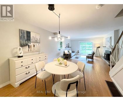 A dining room with a white table and chairs.