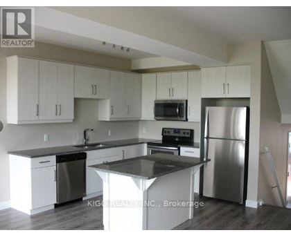 A kitchen with white cabinets and a black countertop.