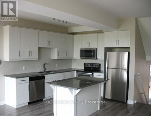 A kitchen with white cabinets and a black countertop.