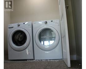 Two white front loading washing machines in a laundry room.