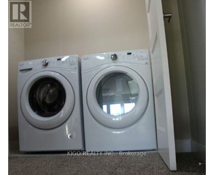 Two white front loading washing machines in a laundry room.